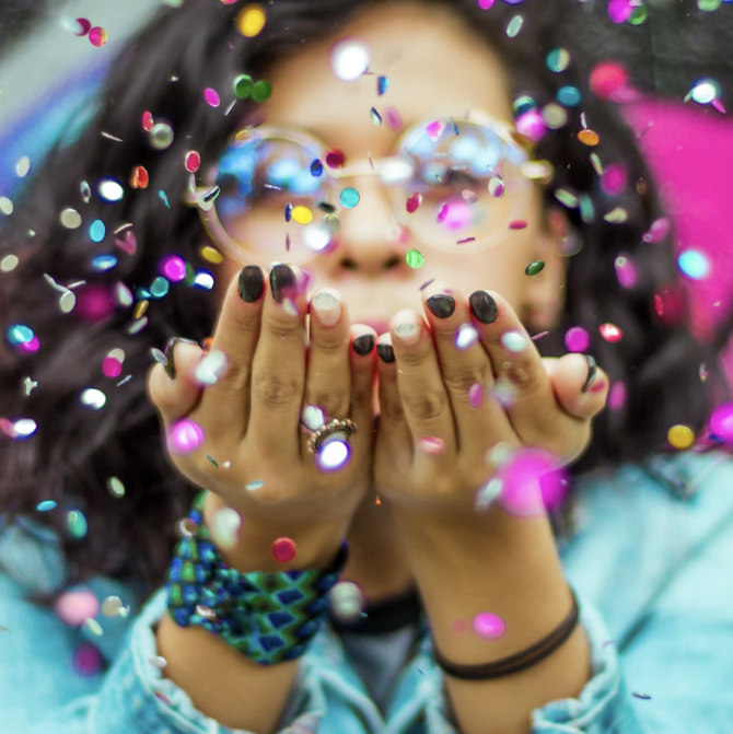 Woman blowing confetti in the air